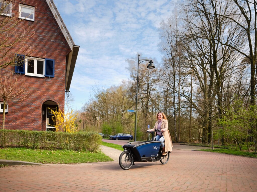 foto van vrouw op bakfiets in woonwijk