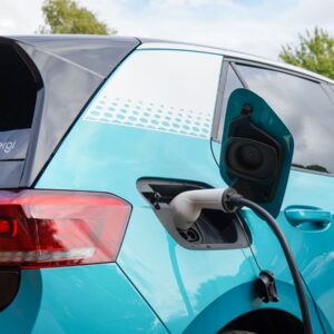 Blauwe elektrische auto aan het opladen via een laadkabel, met het logo van myenergi op de achterruit