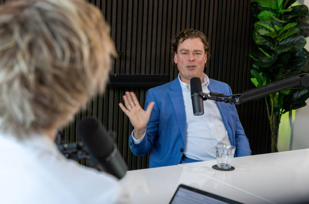 Man spreekt in een podcaststudio achter een microfoon tijdens een gesprek over mobiliteit.