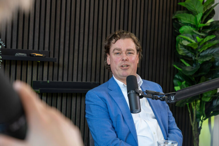 Man spreekt in een podcaststudio achter een microfoon tijdens een gesprek over mobiliteit.