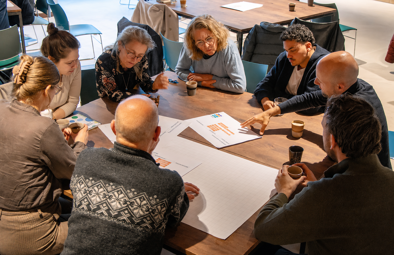 Partners van Natuurlijk!Deelmobiliteit bespreken tijdens een werksessie documenten en inzichten aan een vergadertafel.